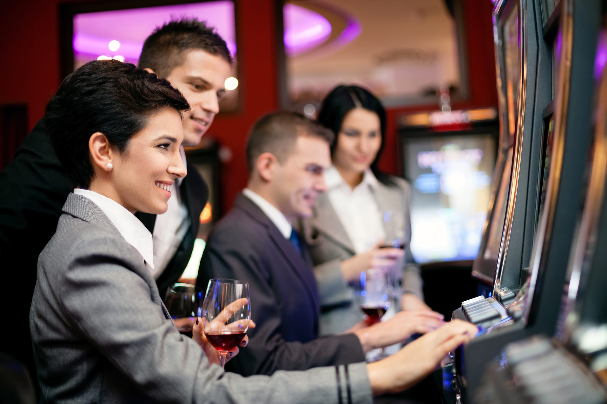 Smiling People Gambling On Slot Machines In The Casino